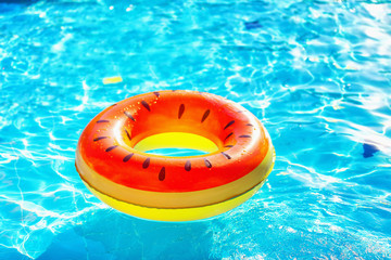 Closeup image of watermelon style inflatable circle floating at swimming pool.