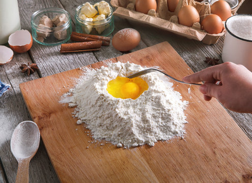 Woman baker makes dough with eggs, butter and flour