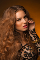 Girl in leopard dress and black shoes on brown background