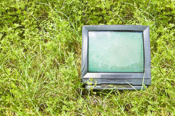 Old television CRT (Cathode ray tube) abandoned in nature - concept image with copy space