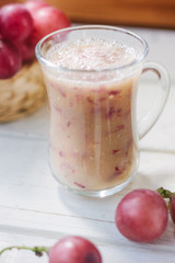 Grape smoothie over the white table.