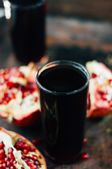 Beautiful pomegranate juice on black rustic surface.