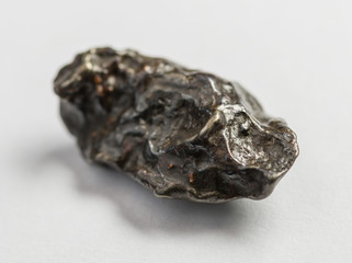Fragment of the Sikhote-Alin meteorite on white background. Selective focus with shallow depth of...