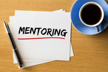 Mentoring - handwriting on papers with cup of coffee and pen, business concept