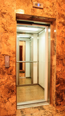 Elevator with new and modern cabin made of bright alloy and metal with modern elevator buttons