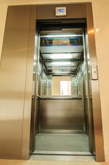 Elevator with new and modern cabin made of bright alloy and metal with modern elevator buttons