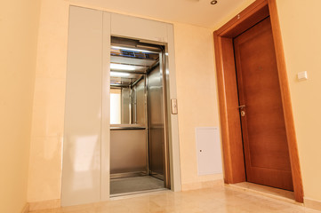 Elevator with new and modern cabin made of bright alloy and metal with modern elevator buttons © Toshe