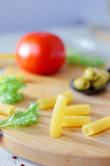 Italian tortiglioni pasta ready to cooking on kitchen board.