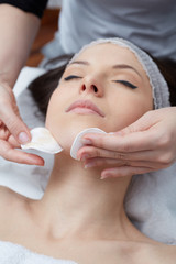  Relaxing beautiful woman having a massage for her skin on a face in beauty salon