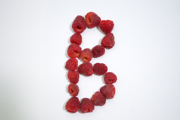 Alphabetical letter B made of raspberries on a white background