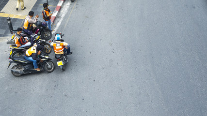 the top view of people with motorcycles stand on the street.