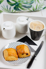 English scones with coffee. Breakfast on white tray. White background, monstera pillow.