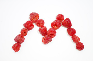Alphabetical letter M made of raspberries on a white background
