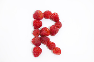 Alphabetical letter R made of raspberries on a white background