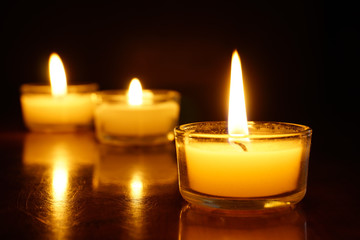 Candles light flame on low light background.