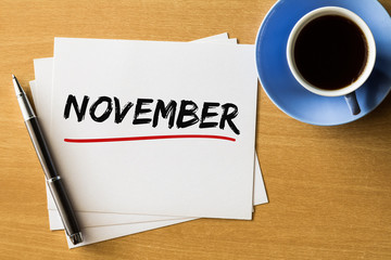 November - handwriting on papers with cup of coffee and pen, concept