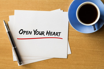 Open your heart - handwriting on papers with cup of coffee and pen, concept