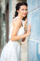 woman in a white dress near the old stone wall