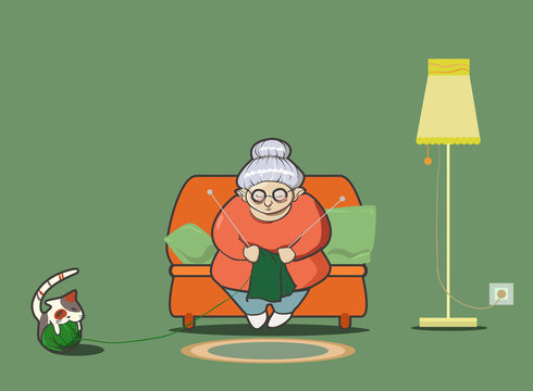 Kniting granny seets on sofa with her happy cat playing with ball. Home.