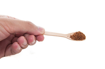 Coffee powder in wooden spoon.