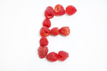 Alphabetical letter E made of raspberries on a white background