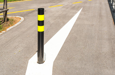 Black and yellow steel bollard on the road