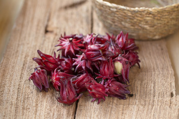 Roselle Hibiscus sabdariffa red fruit flower on wooden background. used for making tea or syrup. selective focus.