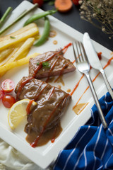 Fresh grilled meat. Grilled beef steak on white plate French fries and Mashed potato with spoon, in serving bowl