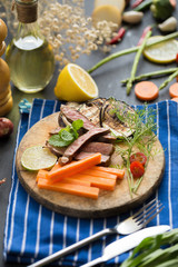 grilled red beef meat sliced with Lemon and carrot on wooden plate