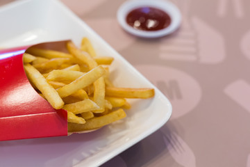 French fries in a red carton box on the white plate