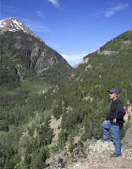 Fototapeta na wymiar A Photographer Stands on a Mountain Overlook
