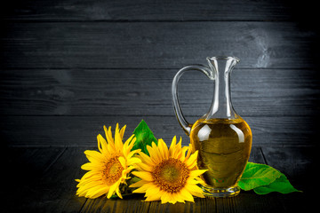 Sunflower oil with flowers on black rustic background