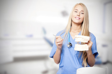 Woman as a dentist with a denture smiling