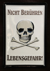 Skull with two crossed shinbone with the text written in German: Nicht Berühren Lebensgefahr, which translated means not touching, danger of death