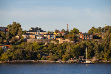 View on luxury cottages and private boat along Stockholm archipelago, Sweden. Summer sunset time.