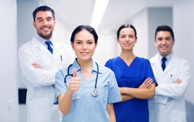 medics or doctors at hospital showing thumbs up