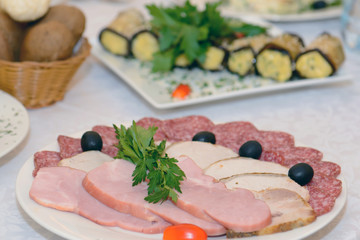 Cold meat appetizer - a dish with sausage and ham on the holiday table. Food ham diner.