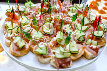 Canape with salami and cucumber on a plate