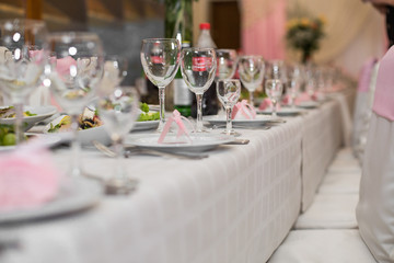 Empty glasses stand on the dinner table prepared for wedding dinner