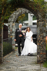 Father walks with a bride along the backyard