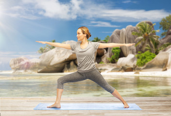 Fototapeta na wymiar woman doing yoga warrior pose on beach