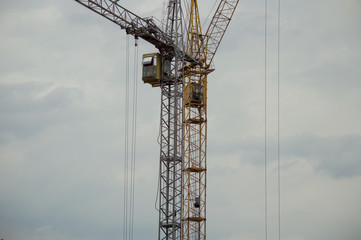 Two cranes against a gray rainy sky background