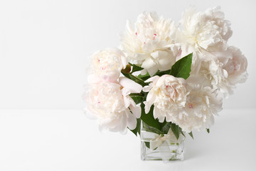 Obraz na płótnie Canvas Glass vase with beautiful peonies on white background