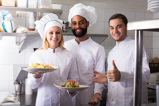 Crew of professional cooks working at restaurant