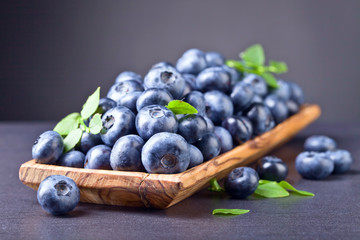 Blueberries in old wooden dish .
