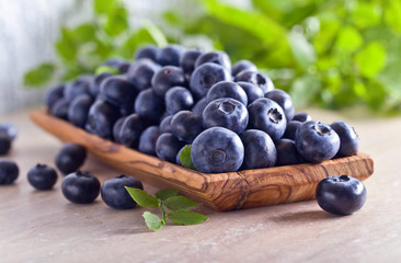 Blueberries in old wooden dish .