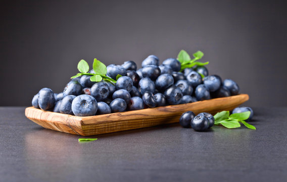 Blueberries in old wooden dish .