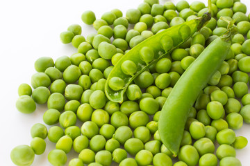 Green peas and pea pod closeup on white. Top view. Food background.