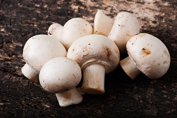 Mushrooms champignons on an old wooden background.