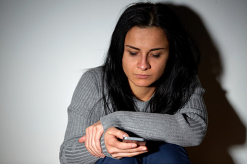 unhappy crying woman with smartphone